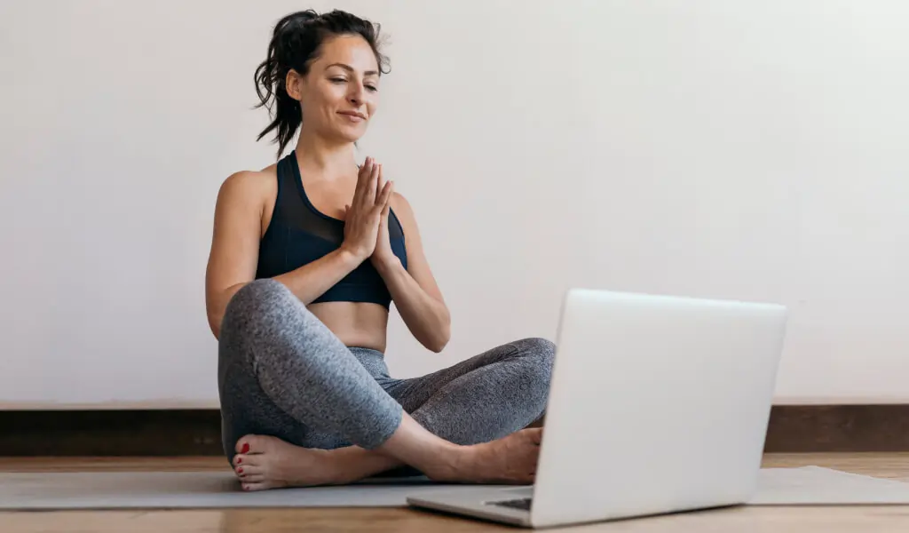 Frau macht einen Online-Praeventionskurs über Yoga